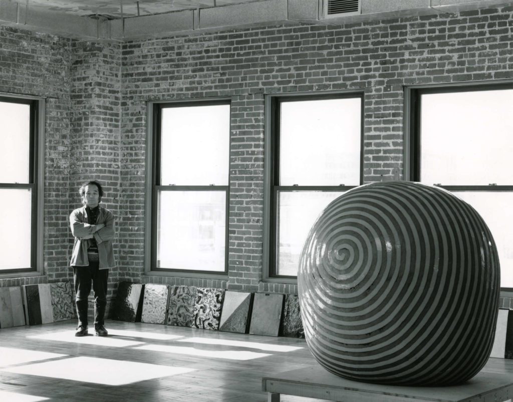 Jun Kaneko in his studio with a finished dango and wall slabs.